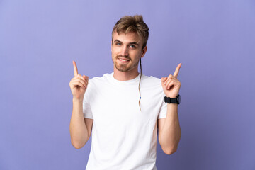 Young handsome blonde man isolated on purple background pointing up a great idea