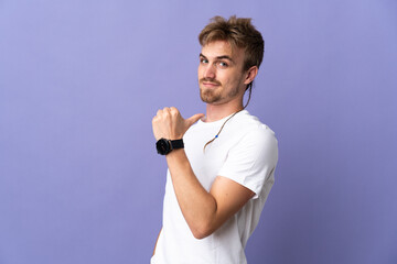 Young handsome blonde man isolated on purple background proud and self-satisfied