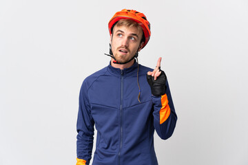 Young cyclist blonde man isolated on white background thinking an idea pointing the finger up