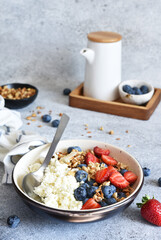 Breakfast - cottage cheese with berries and a cup of coffee, top view. Granola with nuts, honey and strawberries.