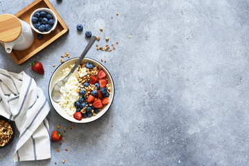 Breakfast - cottage cheese with berries and a cup of coffee, top view. Granola with nuts, honey and strawberries.