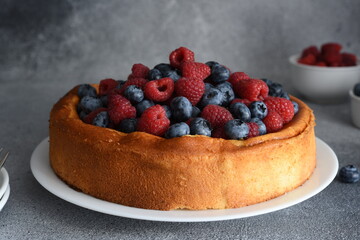 Vanilla pie with raspberries, blueberries on the kitchen table with a cup of coffee. Cheesecake with berries.