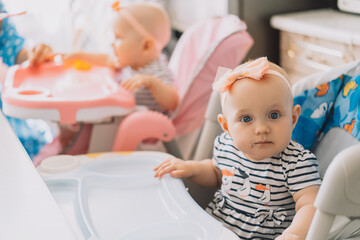 Mom feeds her children from spoon with baby food