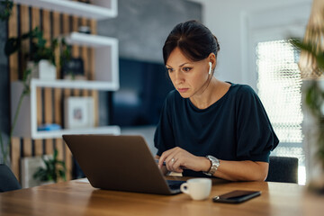 Fototapeta premium Beautiful woman working overtime at home.