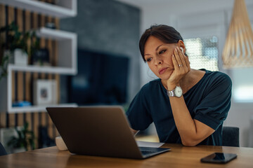 Portrait of a sleepy businesswoman working on laptop.