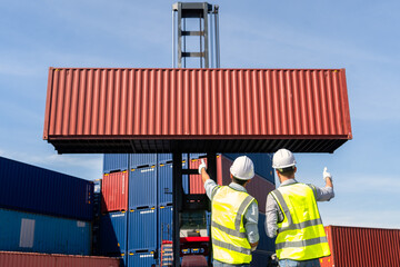 Engineers are overseeing the transportation of cargo with containers inside the warehouse....