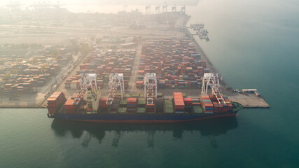 Obraz premium Container ship in export and import business and logistics. Shipping cargo to harbor by crane. Water transport International. Aerial view and top view. 