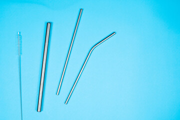 A set of silver colour metal drinking straws on a blue background