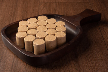 Peanut candy (paçoca or pacoca) Traditional Brazilian candy based on peanuts, placed on a wooden bowl. Selective Focus.