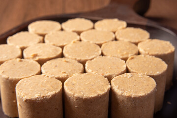 Peanut candy (paçoca or pacoca) Traditional Brazilian candy based on peanuts, placed on a wooden bowl. Selective Focus.