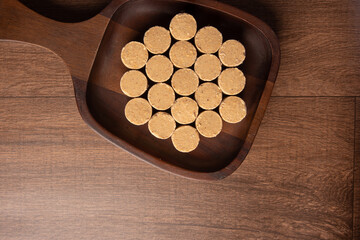 Peanut candy (paçoca or pacoca) Traditional Brazilian candy based on peanuts, placed on a wooden bowl. top view.