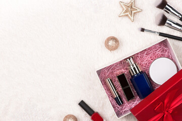 Naklejka premium Flat lay of christmas ball, gift and cosmetic. Holiday Background. Beauty concept.