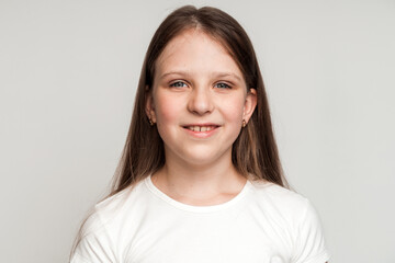 Portrait of cheerful little girl smiling funny and carefree, showing two front teeth. Healthy happy...