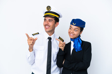 Airplane pilot and mixed race air hostess isolated on white background pointing finger to the side in lateral position