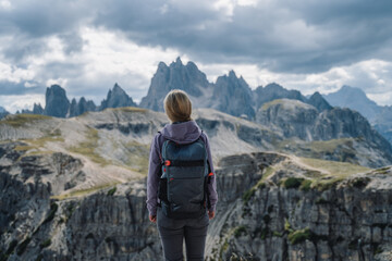 Woman hiker with backpack against Cadini di Misurina mountain group range of Italian Alps, Dolomites, Italy, Europe