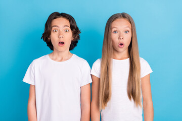 Photo portrait children staring amazed opened mouth in casual clothes isolated pastel blue color background