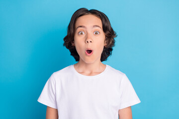 Photo of shocked excited funny schoolboy look camera open mouth wear white t-shirt isolated blue color background