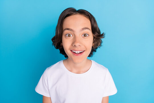 Photo portrait schoolboy smiling surprised staring excited in white t-shirt isolated pastel blue color background