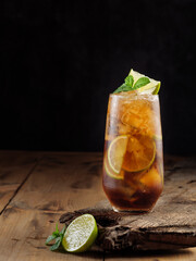 Cuba libre cocktail on a wooden table. Copy space.