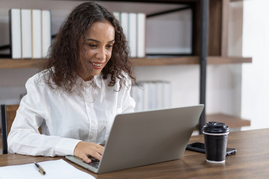 Young business woman working  and typing with laptop computer in the office. Smiling woman working with laptop computer