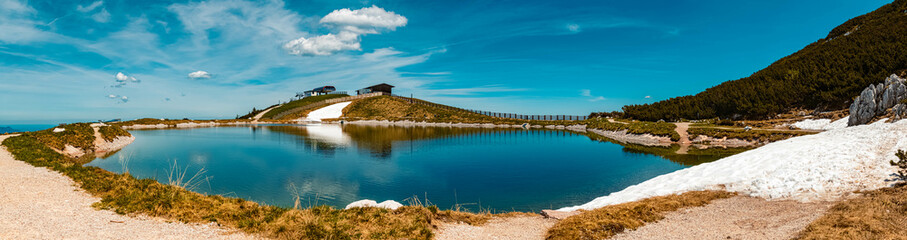 Fototapeta na wymiar High resolution stitched panorama of a beautiful alpine summer view with reflections in a pond at the famous Steinplatte summit, Waidring, Tyrol, Austria