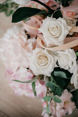 Pink flowers and two golden wedding rings on white background.