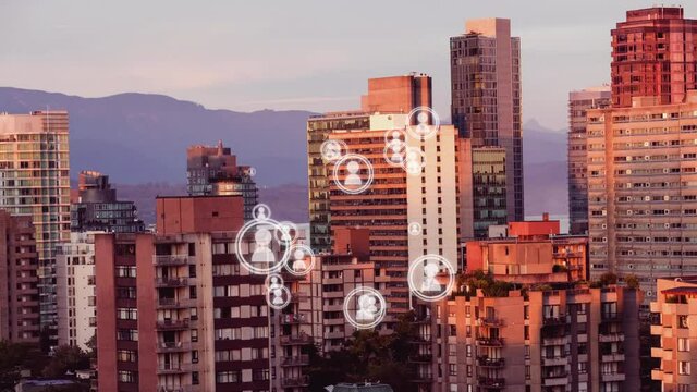Animation of multiplying people icons moving over modern cityscape and mountain range