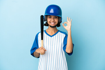 Baseball mixed race player woman with helmet and bat isolated on blue background showing ok sign with fingers