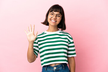 Young mixed race woman isolated on pink background counting five with fingers