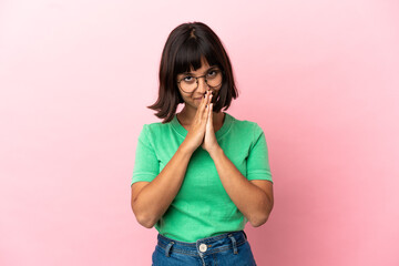 Young mixed race woman isolated on pink background keeps palm together. Person asks for something