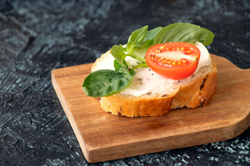 Fototapeta na wymiar close-up vegetable sandwich with cream cheese, tomato and basil. serving a vegetarian sandwich or snack. flat lay