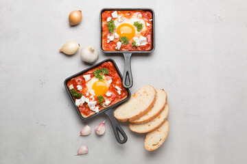 Fried eggs with tomatoes and cheese in a frying pan. Shakshuka, a Jewish dish.
