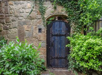 Fototapeta na wymiar An old wooden door in a stone wall.