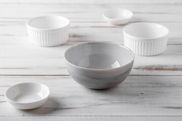 Empty assorted plates on a white wooden background. Table setting.