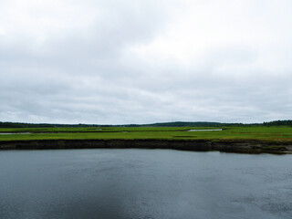 View of lawn with ponds on a cloudy day. Scenery of natural green field, turf