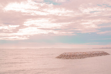 sunset over the sea with a pastel sky of pink.
