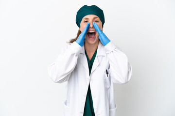 Surgeon caucasian woman in green uniform isolated on white background shouting and announcing something