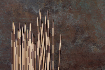 Traditional Japanese Board Game  Mikado. Bamboo sticks from the game on a rustic brown background hand painted. Top view, macro. Exotic games