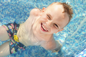 Child In a swimming pool. Smiling. Happy. Refreshing procedure. Summer. Seasonal 