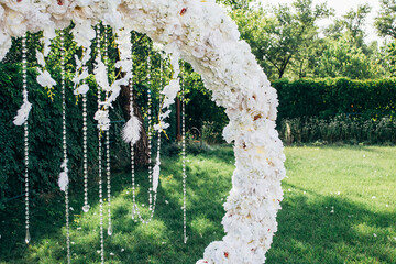 wedding arch made of white flowers round shape