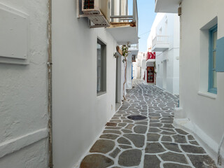 Whitewashed houses empty cobblestone alley at Naousa village, Paros island, Greece.
