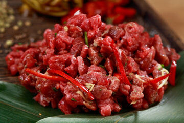 Raw minced meat  tar tar or tartare on a wooden plate. Restaurant food. 