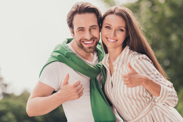 Photo of young cheerful couple happy positive smile hug show thumbs-up like fine feedback ad choose outdoors
