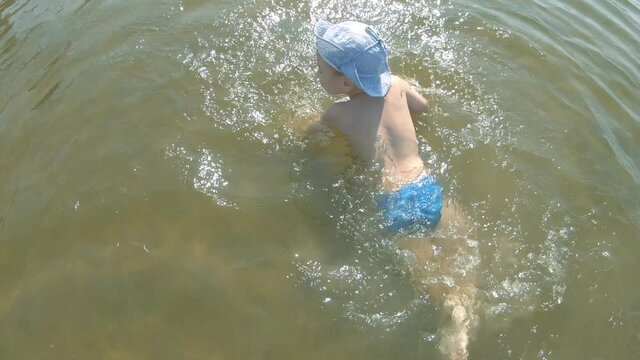 A three-year-old boy swims in the Dnieper River