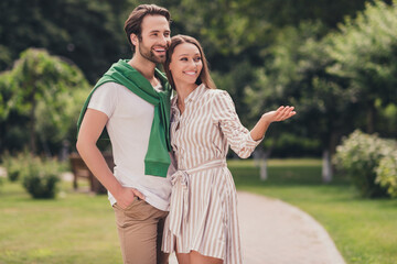 Photo of young attractive couple happy positive smile date feelings girl demonstrate hand empty space walk outdoors