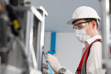 factory worker using touch screen industrial control panel machine for production