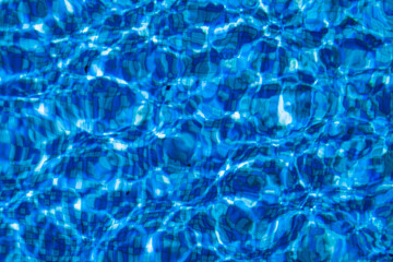 Solar glare on the water in the pool. Blue surface water background