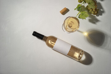 Bottle of white wine with label. Glass of wine and grape. Wine bottle mockup. - 451836497