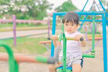 Fototapeta na wymiar Little boy, kid having fun on swings at playground
