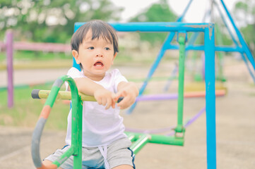 Little boy, kid having fun on swings at playground